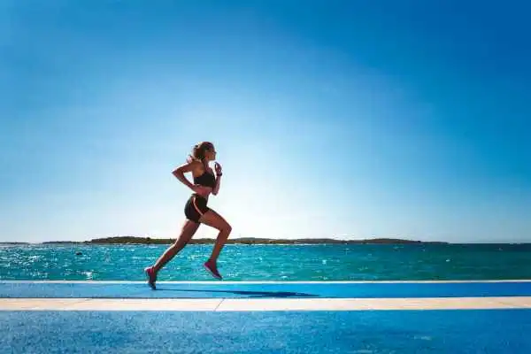 Woman running showing strong leg muscle Owsestry